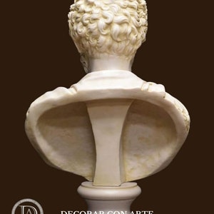 May include: A white plaster bust of a person with curly hair. The bust is on a white pedestal. The bust is facing away from the camera.