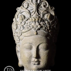 May include: A gray stone sculpture of a woman's head with a detailed crown of flowers and leaves. The woman's eyes are closed and her expression is serene.