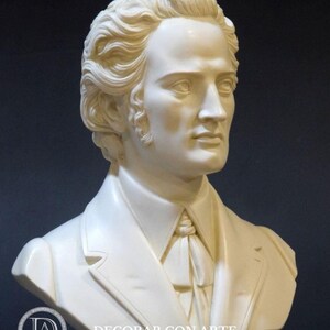 Puede incluir: Busto de m&aacute;rmol blanco de un hombre con el pelo corto y ondulado, que lleva una chaqueta y una corbata. El busto est&aacute; sobre una base negra con la palabra "CHOPIN" inscrita en ella.