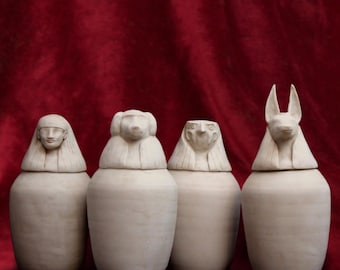 Four canopic jars. 25 cm. Made of reconstituted marble. Ancient Egyptian art