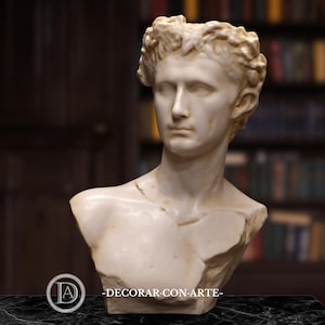 Könnte beinhalten: Eine cremefarbene Büste einer klassischen Figur mit lockigem Haar und einem ruhigen Ausdruck. Die Skulptur ist ein Teil-Torso, der Kopf, Hals und oberen Brustbereich zeigt. Der Sockel ist nicht sichtbar. Der Text "-DECORAR CON ARTE-" befindet sich unten.