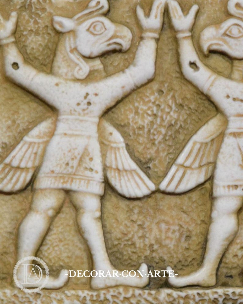 May include: A close-up of a relief sculpture depicting two winged human figures with animal heads. The figures are facing each other and have their arms raised. The sculpture is made of a light-colored stone and has a textured surface.