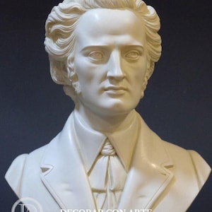 Puede incluir: Busto de m&aacute;rmol blanco de un hombre con el pelo corto y ondulado. El busto es de un hombre que lleva una chaqueta con cuello alto y una corbata de lazo. El busto est&aacute; sobre una base negra con la palabra "CHOPIN" inscrita en ella.