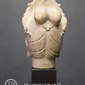May include: A white plaster sculpture of a woman's head with a detailed hairstyle. The sculpture is on a black pedestal.