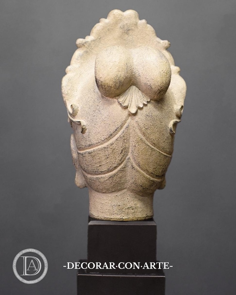 May include: A white plaster sculpture of a woman's head with a detailed hairstyle. The sculpture is on a black pedestal.