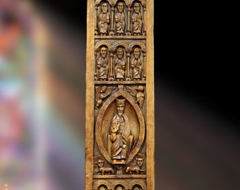May include: A wooden panel with intricate carvings of figures in arched niches. The central figure is a robed person holding a smaller figure. The panel is a rich brown color.