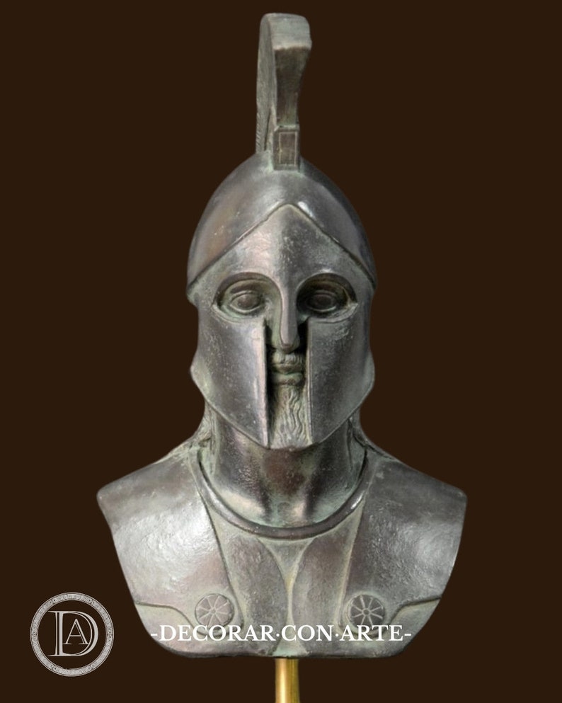May include: A bronze-colored bust of a Spartan warrior, complete with a helmet and chest armor. The bust features a detailed face and beard, with the text "DECORAR CON ARTE" visible in the lower portion of the image.
