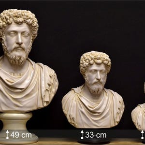 May include: Three white marble busts of the Roman emperor, Marcus Aurelius, in different sizes. The busts are on black bases. The largest bust is 49 inches tall, the middle bust is 33 inches tall, and the smallest bust is 24 inches tall.