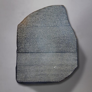Puede incluir: Primer plano de la piedra Rosetta, una gran losa rectangular de color gris oscuro con jeroglíficos egipcios antiguos, griego y escritura demótica tallados en su superficie.