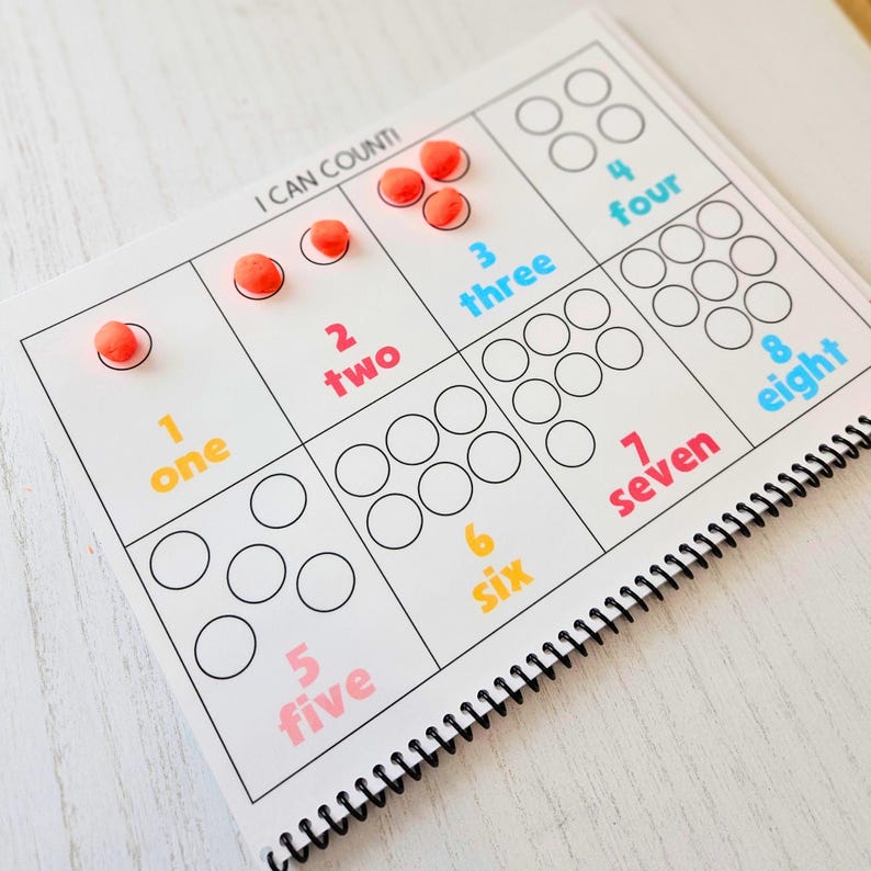 May include: A white and black counting chart with colorful numbers and circles. The chart has the numbers one through eight with corresponding circles to count. The chart is titled "I CAN COUNT!"