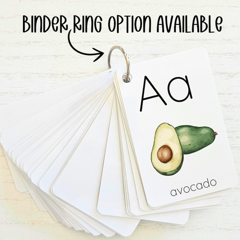 May include: A set of alphabet flash cards with a binder ring. The card shown features the letter "A" and a drawing of an avocado with the word "avocado" printed below.