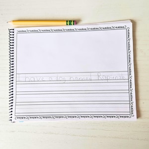 Może przedstawiać: Biały notes ze spiralnym czarnym oprawieniem i czarną ramką. Notes ma liniowane strony, a na pierwszej stronie widnieje tekst "I have a dog named Rapunzel."