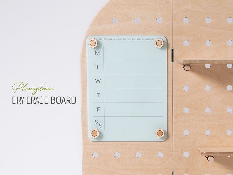 May include: A light blue dry erase board with a weekly calendar layout. The board is made of plexiglass and has four wooden knobs on the corners. The board is mounted on a wooden pegboard with white dots.