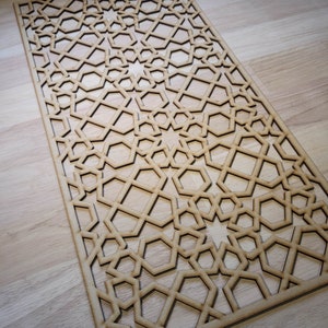 May include: A wooden decorative panel featuring a geometric pattern of stars and hexagons. The panel is made from light brown wood and has a natural finish.