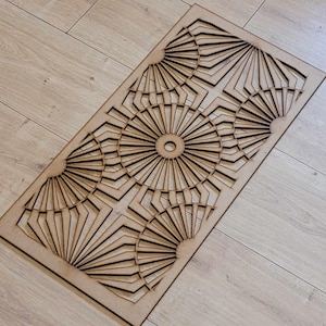 May include: A wooden wall decor with a geometric design featuring multiple overlapping circles with radiating lines. The design is reminiscent of a sunburst pattern.