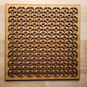 May include: A wooden panel with a geometric pattern cut out. The pattern is made up of repeating hexagons and diamonds. The panel is a light brown colour.