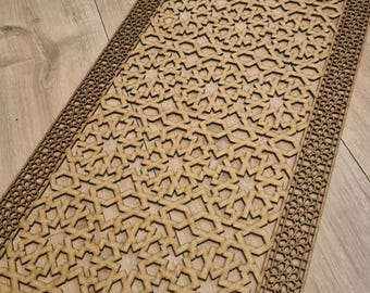 May include: A wooden decorative panel with a geometric pattern of stars and intricate details. The panel is made of light brown wood and has a border of smaller geometric designs.