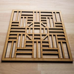 May include: A wooden geometric design with a square shape and a repeating pattern of lines and squares. The design is cut out of a single piece of wood and has a natural wood finish.