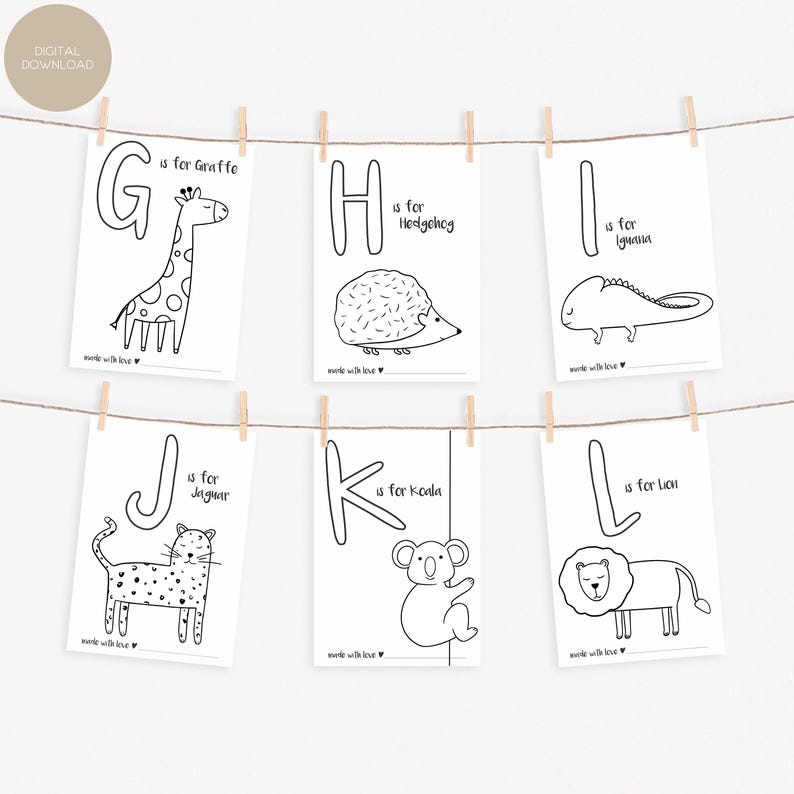 May include: Six black and white alphabet cards with animal illustrations, including a giraffe, hedgehog, iguana, jaguar, koala, and lion. Each card features a large letter and the animal's name. The cards are hanging from a string with wooden clips.