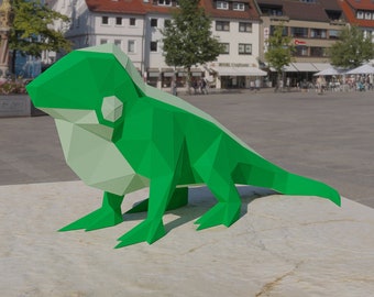 May include: A green origami iguana sculpture with a white underside. The sculpture is made of paper and has a geometric design.