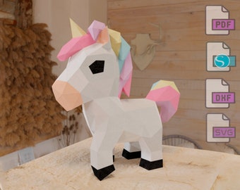 May include: A white origami unicorn with pink, yellow, and blue accents. The unicorn is standing on a light brown surface.