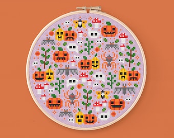 May include: A purple and white cross-stitch embroidery hoop with a Halloween-themed design. The design features pumpkins, bats, ghosts, spiders, and mushrooms.