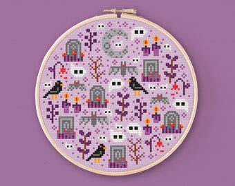 May include: A purple cross-stitch embroidery hoop with a Halloween-themed design. The design features ghosts, bats, crows, tombstones, and candles.
