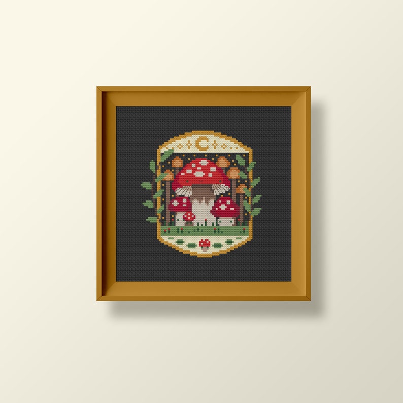 Fungi inspired framed cross stitch chart. The cross stitch design consists on a some mushrooms surrounded by a frame decorated with a moon, stars and leaves. The art style is cottagecore, witchy and whimsical. The colors of the design are red, yellow, orange and green. This cross stitch design is modern, unique and original. Stitched on black Aida fabric. Available to download as a cross PDF stitch pattern.