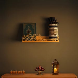 Op de afbeelding: Een gouden plank met Arabische kalligrafie, een groen boek, een zwart en gouden tasje en een kleine lantaarn met een brandende kaars. Datums liggen op een zilveren bord op een houten tafel.