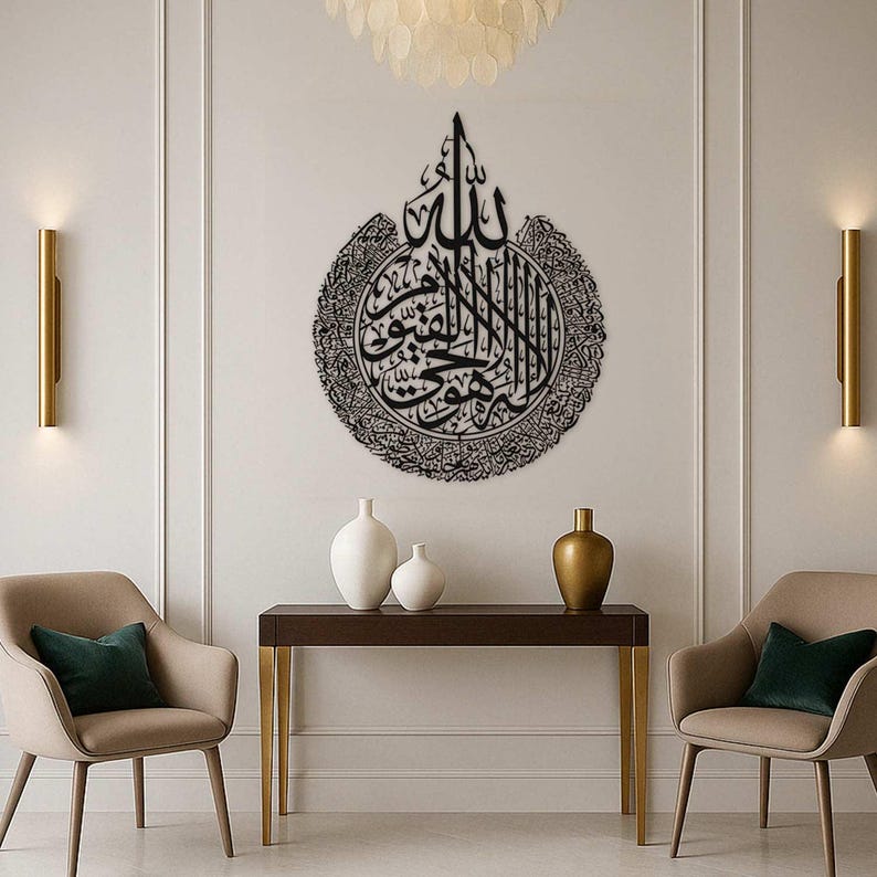 May include: A large, black metal wall art piece featuring Arabic calligraphy. The artwork is circular with intricate details and is mounted on a white wall. The room is decorated with modern furniture and lighting.