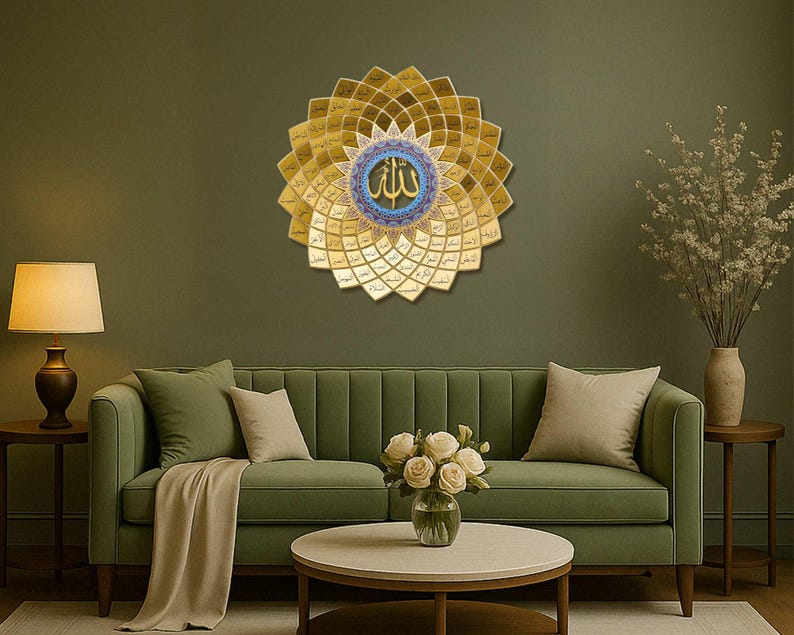 May include: A gold and blue Islamic wall art with the word 'Allah' in the center, surrounded by a floral design. The art is hanging on a green wall above a green sofa with white throw pillows and a bouquet of white flowers on a coffee table.