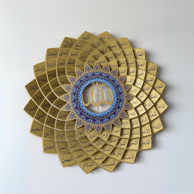 May include: A gold-colored, layered wall art piece with Arabic calligraphy. The design features a central circular element with a blue and gold pattern, surrounded by petal-shaped sections, each inscribed with text.