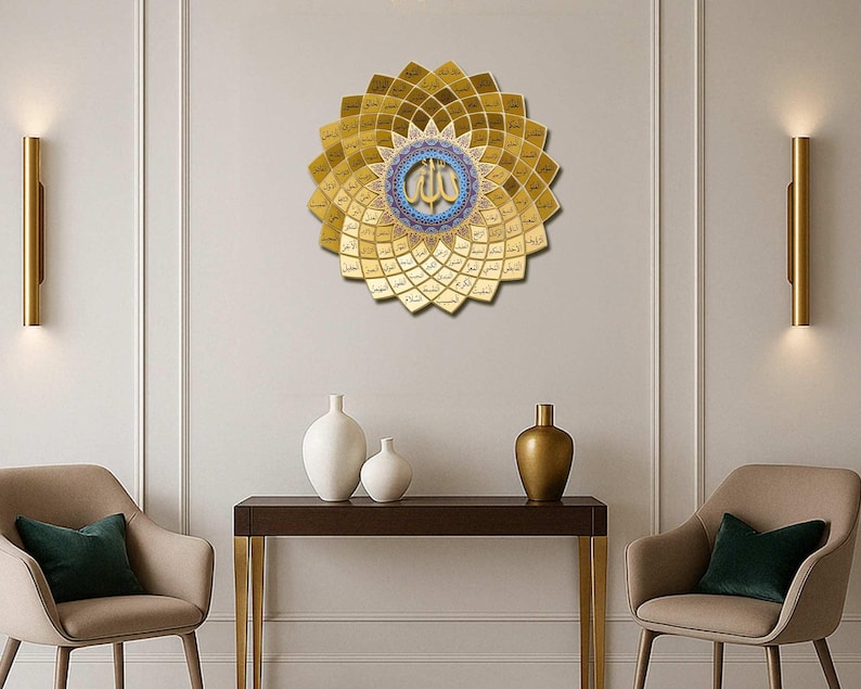 May include: A gold-colored, circular wall art piece with a floral design, featuring Arabic calligraphy in the center. The artwork is mounted on a white wall, with a dark brown table and decorative vases below. Two chairs with green pillows are on either side.