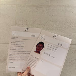 May include: Two white consent forms with the logo "A" in black. One form has a portrait of a woman with dark skin. The forms include sections for medical history, treatment details, and patient information.