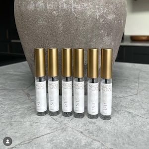 以下が含まれることがあります： 白いラベルに「LISHI Serum」と「MADE IN JADE」と書かれた、金色のボトルが6本あります。