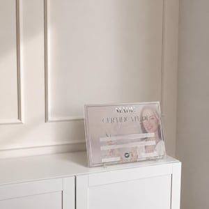 May include: A rectangular acrylic certificate holder displaying a document titled MADE CERTIFICATE OF ACHIEVEMENT. The document features a photograph of a person, blank lines for completion details, and a small circular logo at the bottom centre.