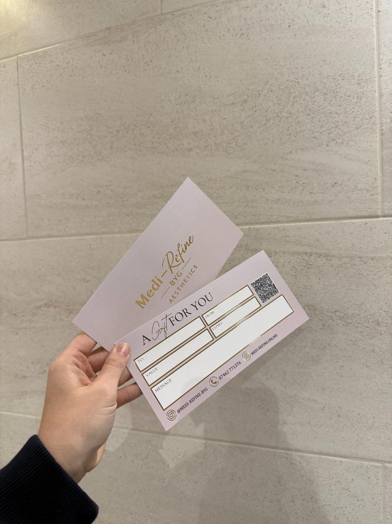 May include: A gift certificate from Medi-Refine BYG Aesthetics. The pink card features gold text and a QR code. The card reads "A Gift For You" with spaces for recipient, sender, value, and a message. The business logo and contact information are also visible.