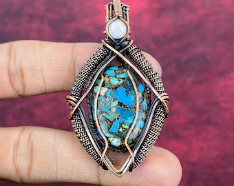 May include: A wire-wrapped pendant featuring a central oval turquoise stone with copper matrix inclusions. The stone is encased in oxidized copper wire coils and geometric framing, topped with a small, round, translucent white moonstone cabochon.