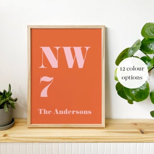May include: A framed print with a peach background and pink lettering. The print says "NW 7 The Andersons".