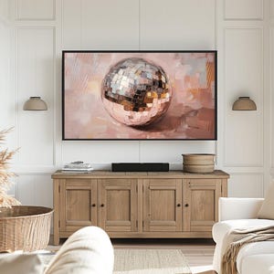May include: A painting of a large, shiny, silver disco ball on a pink background. The disco ball is reflecting light and has a textured surface.