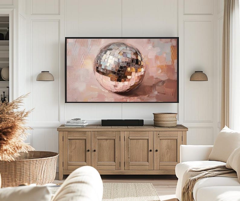 May include: A painting of a large, shiny, silver disco ball on a pink background. The disco ball is reflecting light and has a textured surface.