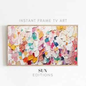 May include: Abstract painting with a white background and colorful, textured brushstrokes in shades of pink, yellow, blue, green, and red. The painting is framed in a light wood frame. "SUN EDITIONS" is written in gray text below the painting.