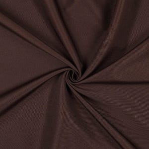 May include: A solid dark brown fabric with a smooth, matte texture. The material is gathered in the center, creating deep, radiating folds and soft shadows that highlight the consistent, uniform color and fine weave of the textile.