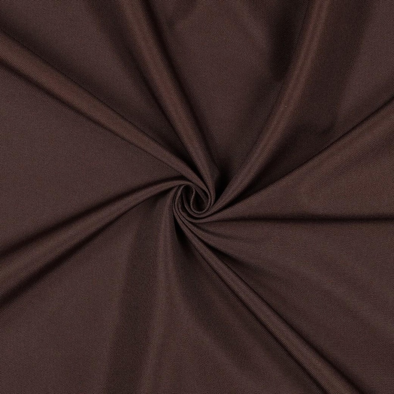 May include: A solid dark brown fabric with a smooth, matte texture. The material is gathered in the center, creating deep, radiating folds and soft shadows that highlight the consistent, uniform color and fine weave of the textile.