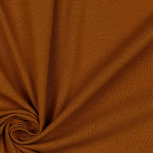 May include: Close-up of a brown ribbed fabric with a soft, textured surface.