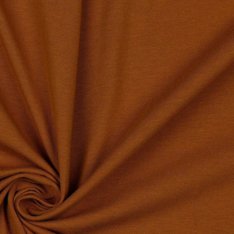 May include: Close-up of a brown ribbed fabric with a soft, textured surface.