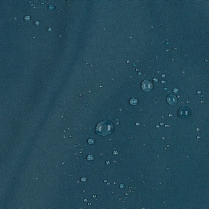 May include: A dark teal fabric surface with a visible woven texture. Numerous clear water droplets of varying sizes are scattered across the material, creating a beaded effect on the surface of the water-resistant textile material.