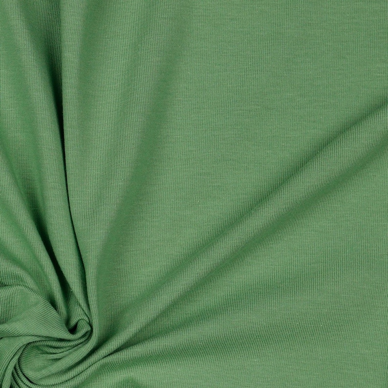 May include: A close-up of a green ribbed fabric. The fabric is soft and has a subtle texture.
