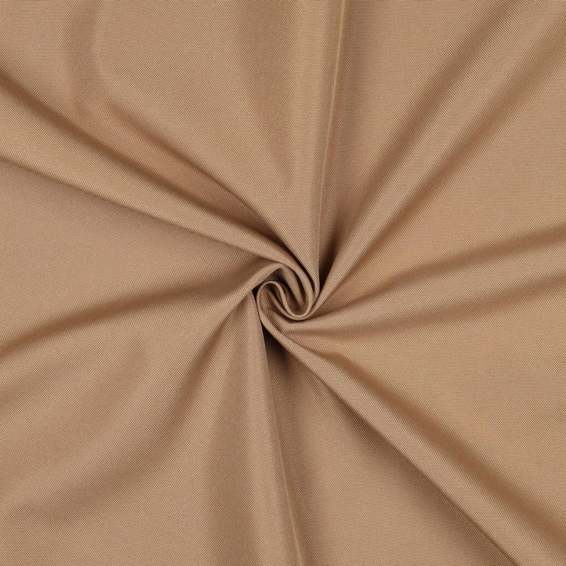 May include: A solid tan fabric with a tight, uniform weave. The material is gathered in the center, creating soft, radiating folds and shadows that highlight the smooth, consistent texture and neutral light brown color of the textile.