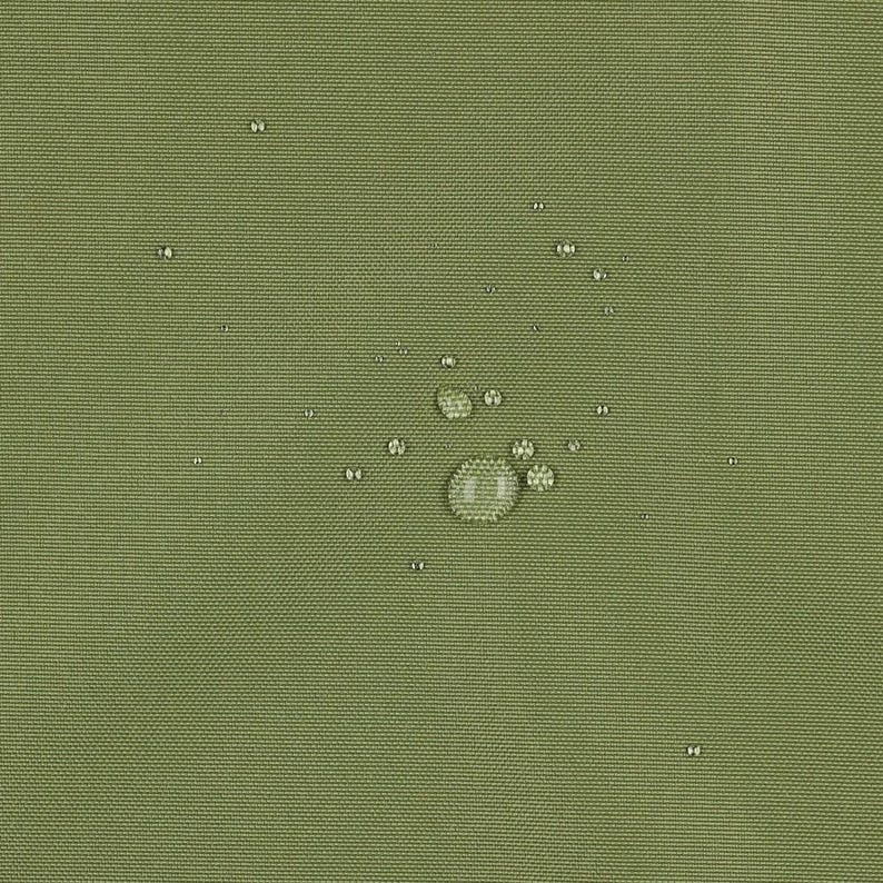 May include: A solid olive green fabric surface with a tight, woven texture. Several clear water droplets of varying sizes are scattered across the material, demonstrating a water-repellent quality on the textile's surface.